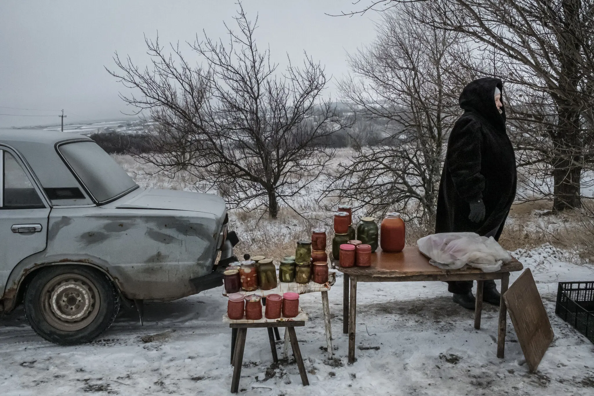 67-річна Людмила чекає покупців, щоб купити її домашню консервацію в селі Шестакове на Харківщині 8 грудня.